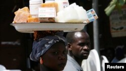 Une tchadienne, produits vend des produits cosmétiques qu'elle porte sur la tête pour subvenir aux besoins de sa famille. 