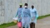 Health workers carry buckets of disinfectant at the newly-constructed Island Clinic and Ebola treatment center in Monrovia, Liberia, September 25, 2014.