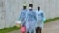 Health workers carry buckets of disinfectant at the newly-constructed Island Clinic and Ebola treatment center in Monrovia, Liberia, September 25, 2014.