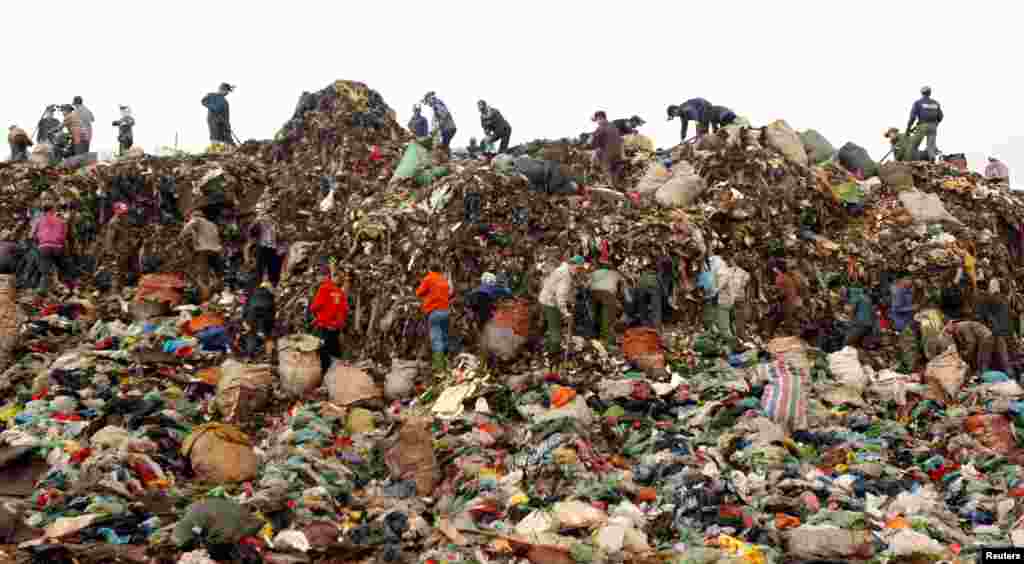 Para pemulung mencari barang yang bisa didaur ulang untuk dijual ke pusat daur ulang, di tempat pembuangan sampah kota Nam Son, utara Hanoi, Vietnam.