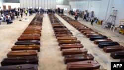 Lebih dari seratus peti jenazah para korban tenggelamnya kapal migran Afrika terlihat berderet di sebuah hangar bandara Lampedusa (5/10). 