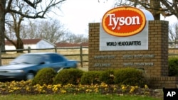 FILE - A car passes in front of a Tyson Foods Inc. sign at Tyson headquarters in Springdale, Ark., Jan. 29, 2006.