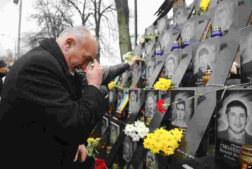 បុរស​ម្នាក់កំពុង​គោរព​វិញ្ញាណក្ខន្ធមនុស្ស​ដែល​បាន​ស្លាប់​នៅ​ក្នុង​ការប៉ះទង្គិច​ជាមួយ​កងកម្លាំង​សន្តិសុខ​នៅ​ Independent Square ក្នុង​ទីក្រុង​ Kyiv ប្រទេស​អ៊ុយក្រែន រំឮក​ខួប​បួន​​ឆ្នាំ​នៃបាតុកម្ម​របស់​ពួកគេ។