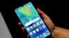 FILE - A staff member holds a Huawei 'Mate20 X 5G' smartphone at the IFA 2019 tech fair in Berlin, Germany, Sept. 5, 2019.