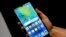 FILE - A staff member holds a Huawei 'Mate20 X 5G' smartphone at the IFA 2019 tech fair in Berlin, Germany, Sept. 5, 2019.