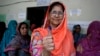 A Pakistani woman shows her ink-stained thumb after casting her ballot at a polling station in Lahore, Pakistan, May 11, 2013. 