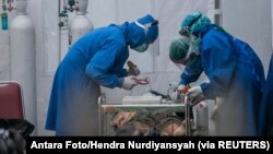 Medicinski radnici liječe osobu koja boluje od Covida.