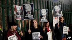 Pendukung Julian Assange memegang spanduk di luar Pengadilan Belmarsh Magistrates di tenggara London, 25 Februari 2020. (Foto: AP)