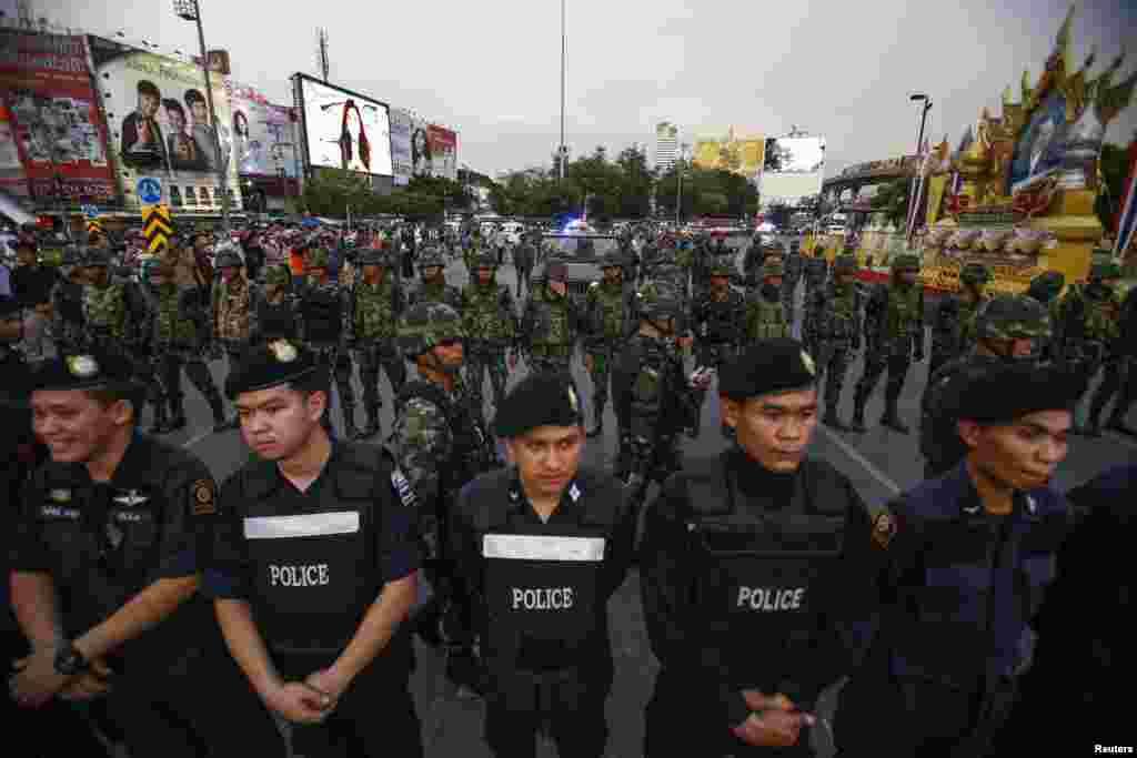Polisi dan tentara berjaga-jaga dalam sebuah protes melawan kekuasaan militer di Monumen Kemenangan di pusat kota Bangkok (26/5).
