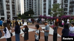 香港选民星期天（11月24日）排队在区议会选举中投票。