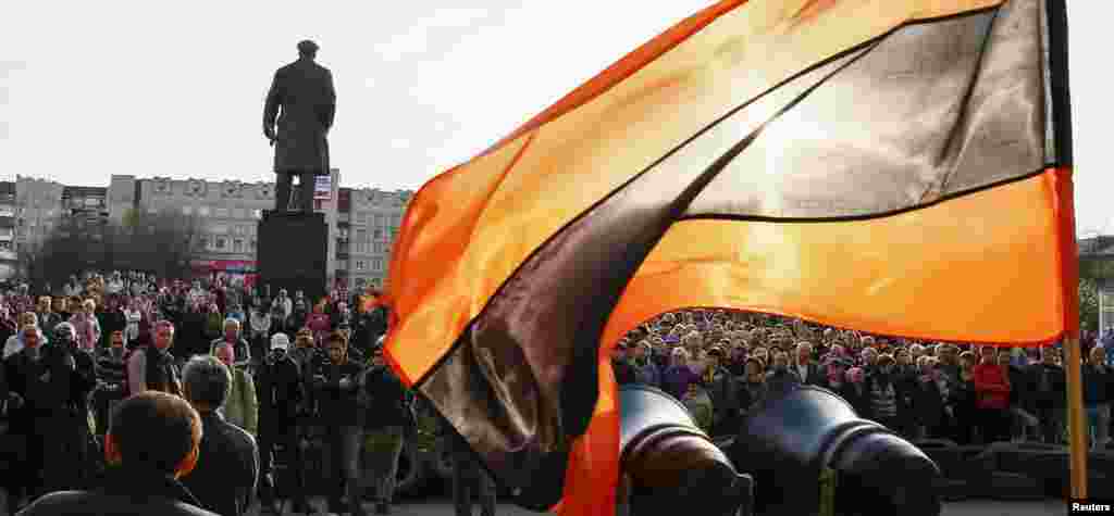 Bendera dalam warna-warna Pita Santo George, yang menjadi simbol sentimen Pro-Rusia, berkibar, sementara para pendukung Pro-Rusia berkumpul di luar kantor Walikota di Slaviansk, Ukraina. &nbsp;