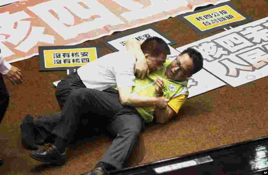 Dua anggota legeslatif yang masing-masing mewakili partai berkuasa dan partai oposisi berkelahi di lantai gedung legislatif di Taipei, Taiwan. Anggota dewan itu saling adu jotos dan saling menyiramkan air&nbsp; sebelum diputuskannya referendum yang diantisipasi untuk meneruskan pembangunan sebuah pembangkit listrik yang keempat.