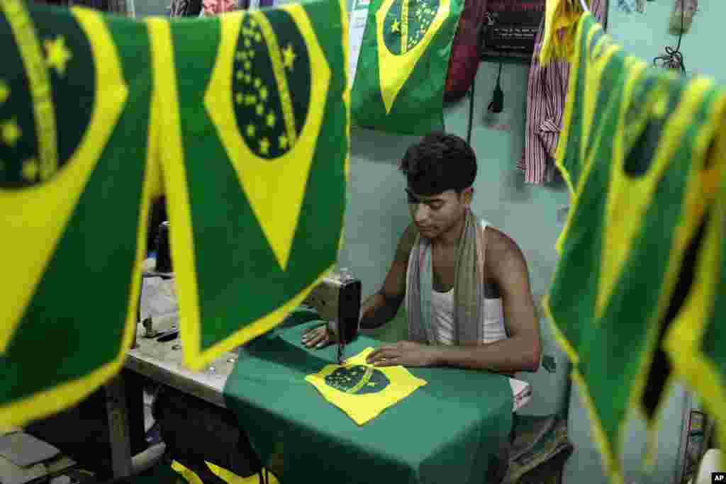 A tailor sews Brazilian national flags to be sold to football enthusiasts ahead of the World Cup, in Dhaka, Bangladesh, May 31, 2014.