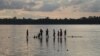 Cambodians bathe in the Mekong River while waiting for the sun to set in Stung Treng province, Cambodia, July 16, 2020. (Sun Narin/VOA Khmer) 