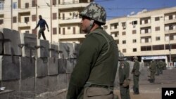 Egyptian army soldiers stand guard in front of the presidential palace, in Cairo, December 9, 2012.