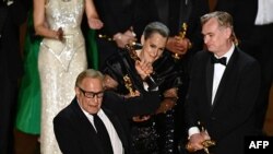 የፊልም አቀናባሪዎቹ እንግሊዛዊዋ ኤማ ቶማስ፣ አሜሪካዊው ቻርለስ ሮቨን፤ እንዲሁንም እውቁ ፊልም ሠሪ ክሪስቶፈር የፊልም አቀናባሪ ኖላን ‘ኦፕንሃይመር’ በተባለው ፊልማቸው በ96ኛው ዓመታዊ የፊል አካዳሚ ሽልማት በሆሊውዱ ዶልቢ የቴአትር መድረክ ለዓመቱ ምርጥ ሲኒማ የተዘጋጀውን ሽልማት በጋራ ሲቀበሉ። 