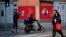 FILE PHOTO: People cross a street in front of posters depicting late Chairman Mao Zedong (R) and China's President Xi Jinping in Shanghai, China, March 1, 2016. 