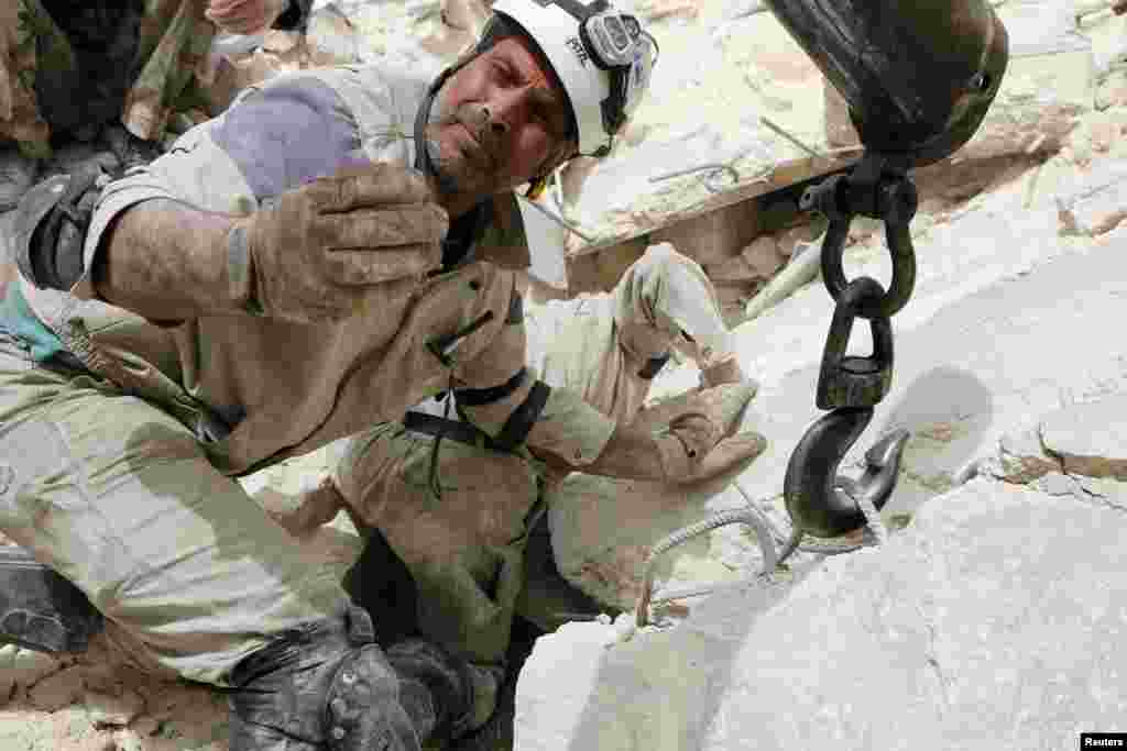 Seorang anggota tim penyelamat tampak di lokasi yang menurut para aktivis telah dijatuhi bom barel oleh pasukan yang setia kepada Presiden Suriah Bashar al-Assad di lingkungan Karam al-Beik di Aleppo. &nbsp;