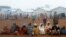 FILE - Congolese families sit at the Kyangwali refugee settlement camp, Uganda, March 19, 2018. 