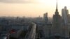 Vehicles move along a road near the buildings of the Moscow International Business Centre (R, back) in Moscow, Sept. 17, 2014.