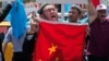 FILE - Uighurs living in Turkey and Turkish supporters, chant slogans before burning a Chinese flag, July 5, 2015. Since 2013, thousands of Uighurs, a Turkic-speaking Muslim minority from western China, have traveled to Syria to train and fight alongside al Qaida.