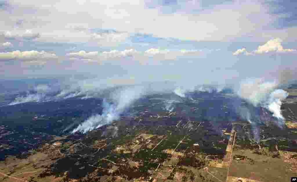 Plumes of smoke rise from a wildfire burning in the densely wooded Black Forest area northeast of Colorado Springs, Colorado, June 13, 2013. 