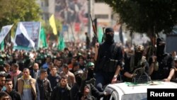 اعضای گروه شبه نظامی حماس در مراسم تشییع جنازه مازن فقهاء، از اعضای ارشد آن گروه، در شهر غزه - ۵ فروردین ۱۳۹۶ 