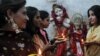 FILE - Pakistani Hindu women hold earthen oil lamps on the occasion of Diwali, in Lahore, on October 26, 2011. During Diwali, people honor Lakshmi, the Hindu goddess of wealth. 