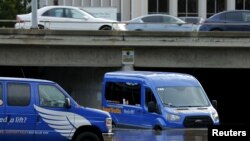 2016年1月6日加利福尼亚州圣迭戈一位机场班车司机缓缓通过洪水区。