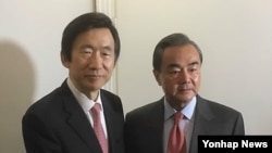왕이(오른쪽) 중국 외교부장과 윤병세 한국 외교부 장관이 18일 독일 뮌헨 안전보장회의 현장에서 만나 인사하고 있다. 