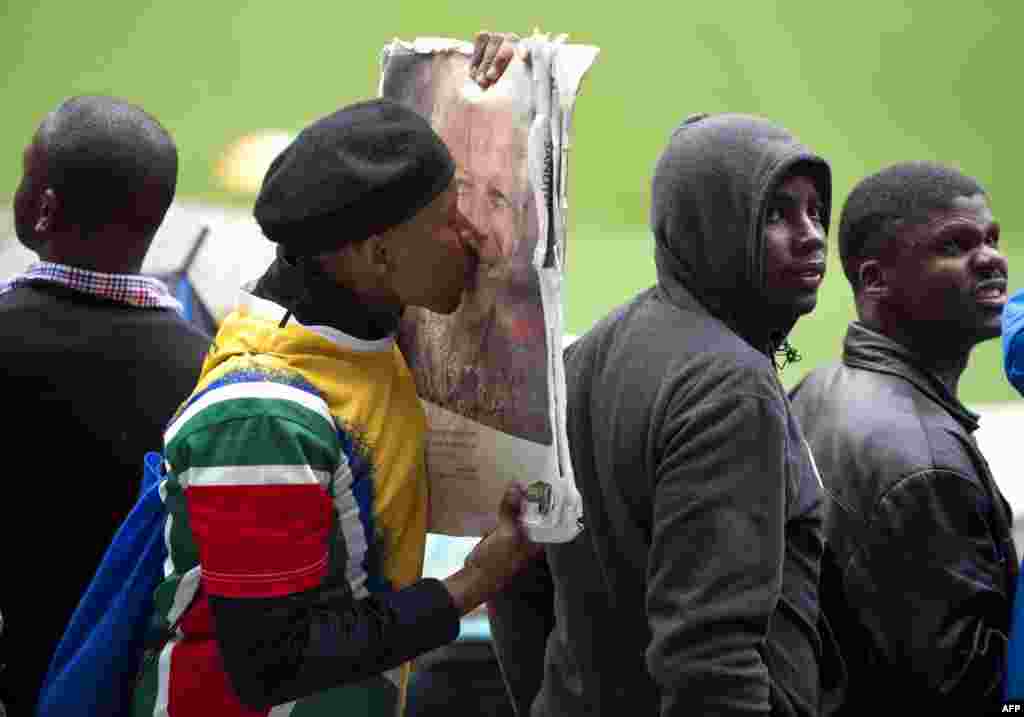 Seorang pria mencium potret mendiang Nelson Mandela saat upacara penghormatan terhadap almarhum di Stadium &#39;Soccer City&#39; Johannesburg, Afrika Selatan.