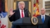 President Donald Trump, accompanied by Vice President Mike Pence, right, speaks during a signing ceremony for executive orders regarding trade in the Oval Office at the White House, March 31, 2017, in Washington. 