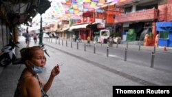 یک زن در حال کشیدن سیگار در بانکوک