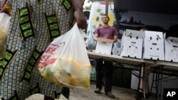 FILE - Seona Ngufor of Cameroon carries bags of squash.