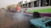 FILE - A bus leaves as smoke is seen at a bus park in Abuja, Nigeria, February 1, 2017. 