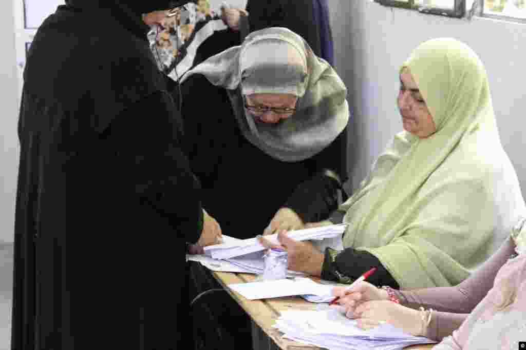 Para pemilih di Mesir menyalurkan suara mereka dalam pilpres di TPS yang dibangun di sebuah SD di distrik Sayida Zeinab di Kairo, pada hari pertama pemilu putaran kedua yang bersejarah, Sabtu (16/6).