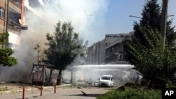 مأموران آتشنشانی در حال خاموش کردن آتش ناشی از انفجار خودروی بمب‌گذاری شده، شهر وان