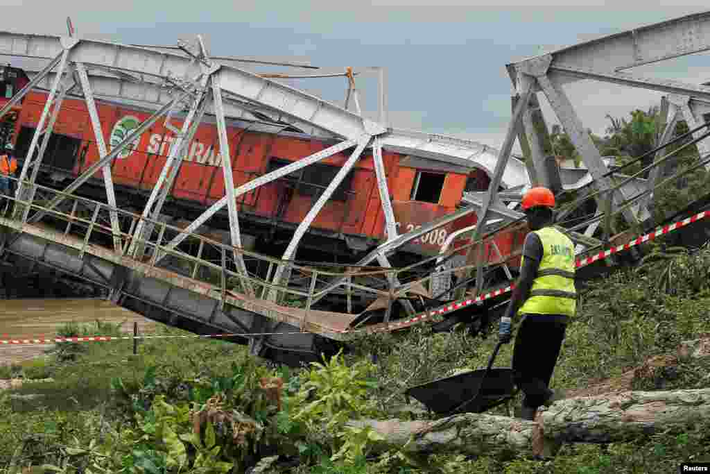 កម្មករ​ម្នាក់​ដើរ​ជិត​ស្ពាន​ផ្លូវ​រថភ្លើង​បែក​​បាក់​មួយ​ ដែល​ស្ពាន​នេះ​ភ្ជាប់​ប្រទេស​ប៊ូគីណា ហ្វាសូ​ទៅ​កាន់​ប្រទេស​កូតឌីវ័រ​ ក្នុង​ក្រុង Dimbokro ប្រទេស​កូតឌីវ័រ។&nbsp;