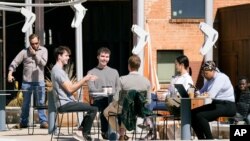 Maskless people gather outside a shop in Dallas, Texas, March 3, 2021, a day after the state's governor, Greg Abbott, lifted coronavirus restrictions.