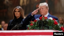 ፕሬዚዳንት ዶናልድ ትረምፕ እና ቀዳሚት እመቤት ሜላንያ ትረምፕ የተወካዮች ምክር ቤቱ እልፍኝ ተገኝተው ለጆርጅ ኧርበርት ዋከር ቡሽ አስከሬን ክብር ሲሰጡ። ሰኞ፤ ኅዳር 25/2011 ዓ.ም. 