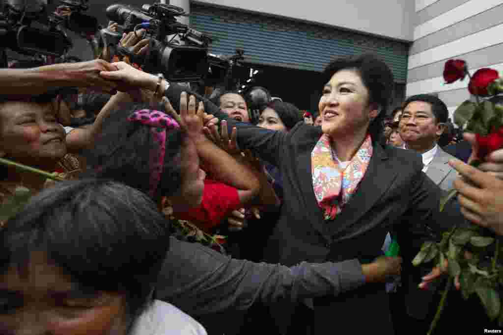 Perdana Menteri Thailand yang baru diturunkan Yingluck Shinawatra menyapa para pendukungnya saat meninggalkan kantor Menteri Pertahanan Permanen di Bangkok (7/5). (Reuters/Athit Perawongmetha)