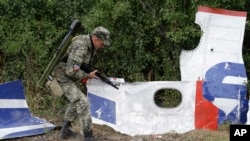 말레이시아항공 MH17편 추락한 우크라이나 동부 지역에서 9일 친러싱아계 반군이 비행기 파편 조각을 살펴보고 있다.