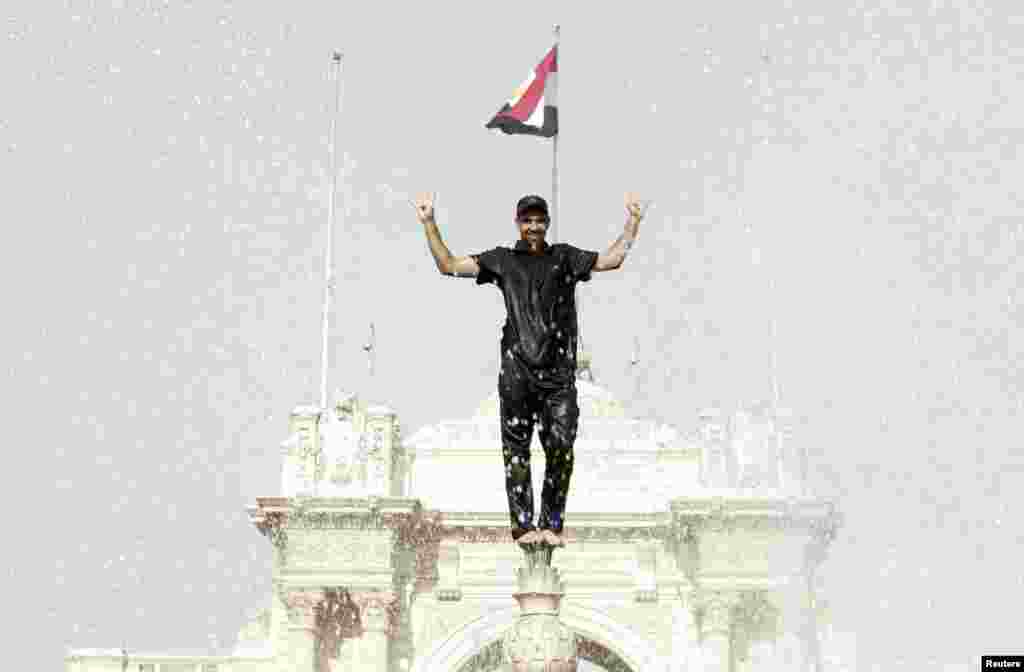 Seorang pengunjuk rasa berdiri di atas air mancur di depan Istana Qubba di Kairo, Mesir. Ribuan pendukung mantan Presiden Mesir yang terguling, Mohamed Morsi, berunjuk rasa di ibukota Kairo, di kota terbesar kedua Alexandria dan di kota-kota pesisir dan kota-kota di sekitar Nil lainnya, seperti dilaporkan sumber-sumber keamanan.