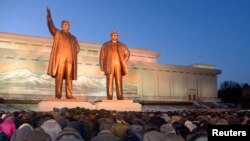 Warga North Korean memberikan penghormatan kepada patung mendiang pemimpin mereka Kim Il Sung (kiri) dan Kim Jong Il di Mansudae, Pyongyang (16/12).