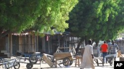 Mutane sun tsere suna tsallake shingaye, kuma sun rufe shagunansu biyo bayan harin kunar bakin waken na, Maiduguri, Najeriya, Talata, Nuwamba 25, 2014.