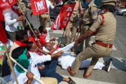 FILE - Policemen detain activists of various organizations as they block a highway during a nationwide shutdown called by thousands of Indian farmers protesting new agriculture laws in Hyderabad, India, Feb. 6, 2021.