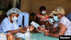 FILE - A man receives a certificate after being vaccinated against the coronavirus disease (COVID-19) at Wilkins Hospital in Harare, Zimbabwe, March 24, 2021.
