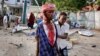 A Somali helps an injured civilian who was wounded in a bomb blast near the Sahafi hotel in the capital Mogadishu, Somalia, Nov. 9, 2018.
