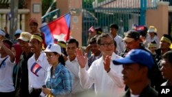Pemimpin oposisi Kamboja Sam Rainsy (tengah) bertepuk tangan saat memimpin para pendukungnya melakukan aksi unjuk rasa di Phnom Penh, Kamboja (15/9).