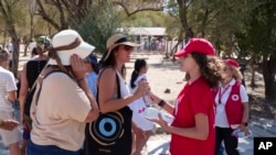 资料照片：希腊雅典的红十字会志愿者向游客发放饮用水。(2024年7月17日)